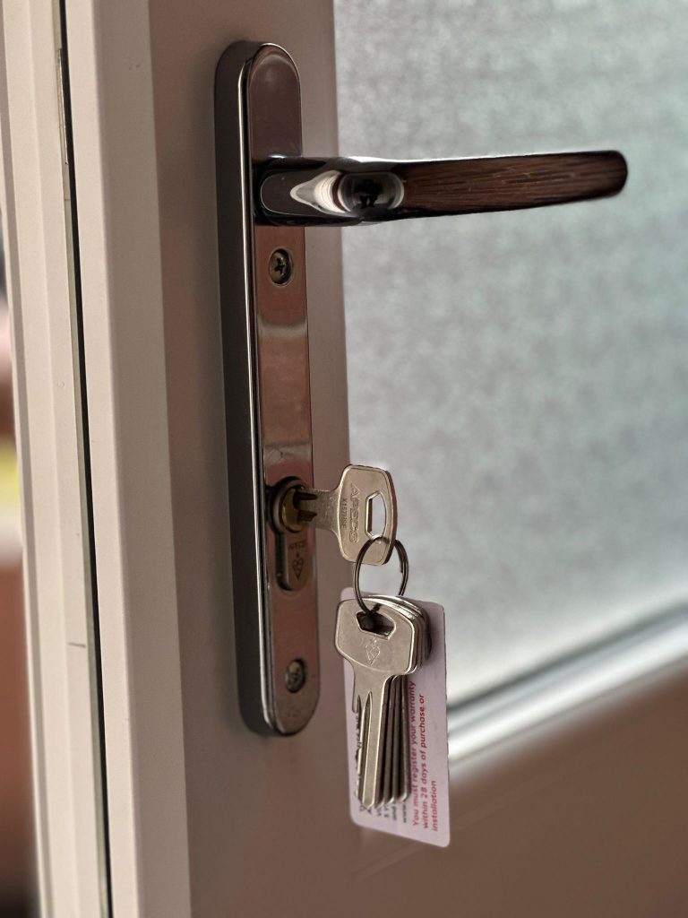 New cylinder and keys on a back door with frosted glass in Alfreton