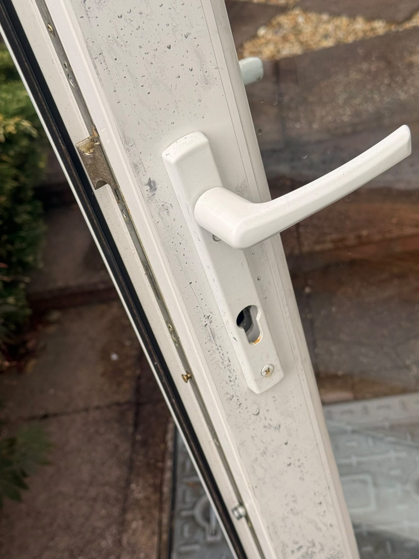 Break-in damage to a patio door lock — cheap outdated cylinder snapped by burglars