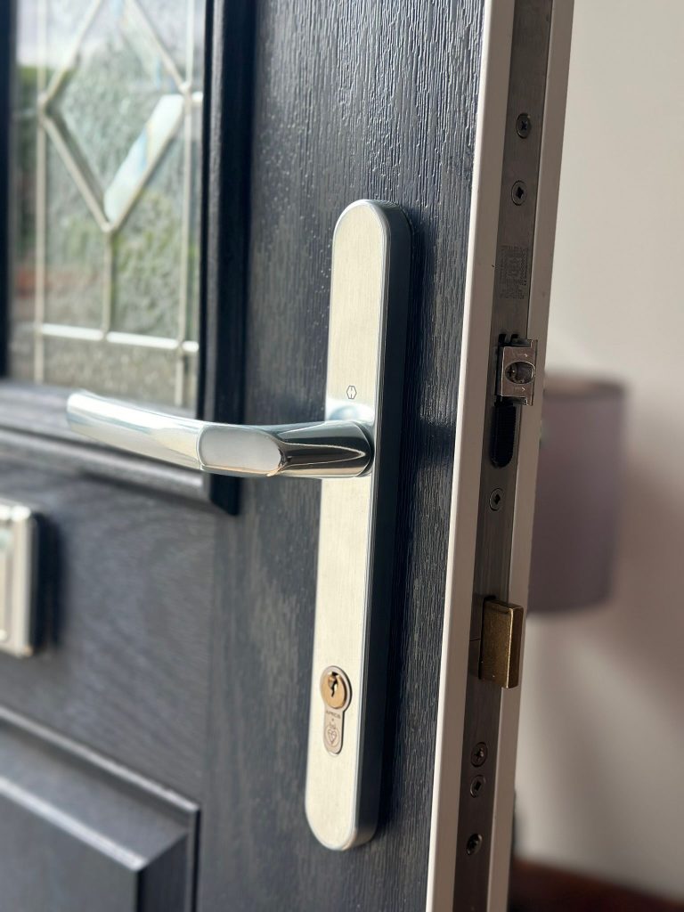 Chrome handle and 3-star cylinder on a composite door with leaded glass in Bramcote
