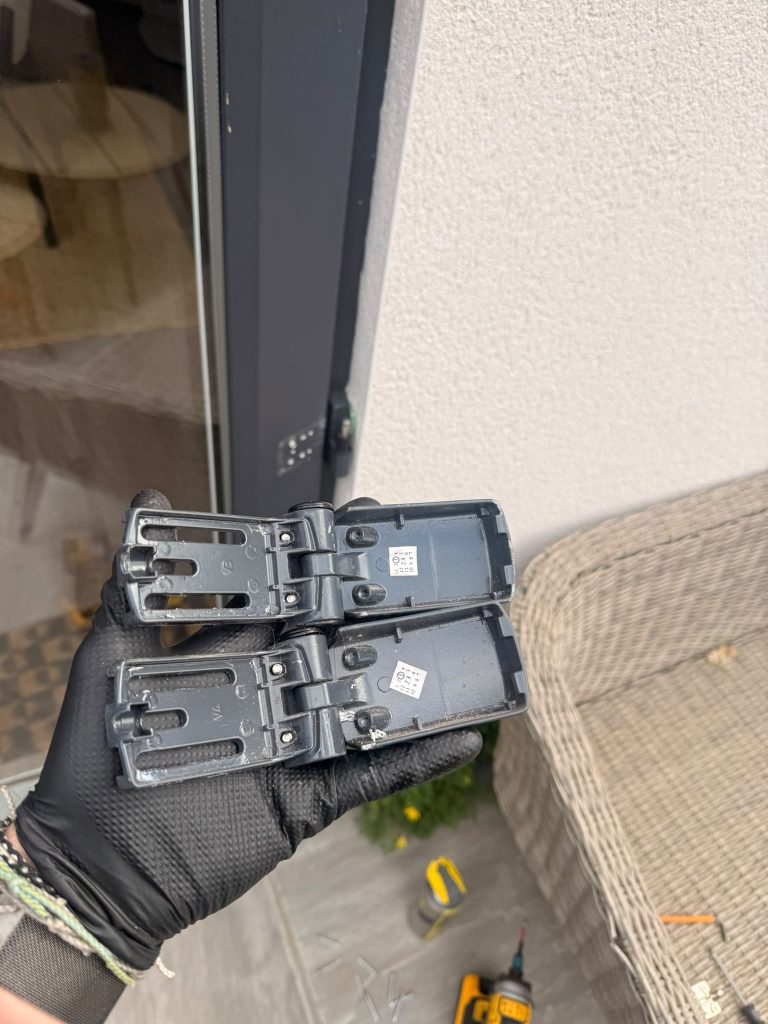 Pair of worn flag hinges removed from an anthracite composite door in Arnold