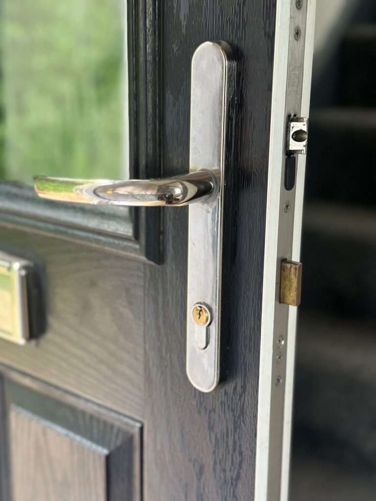 Chrome handle and new cylinder on a dark composite door in Eastwood