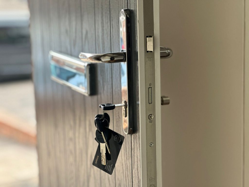 Hook-bolt multipoint and chrome handle on a grey composite door in Calverton