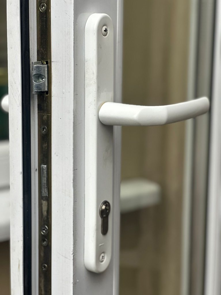 Multipoint strip and white handle on a uPVC French door in Sandiacre
