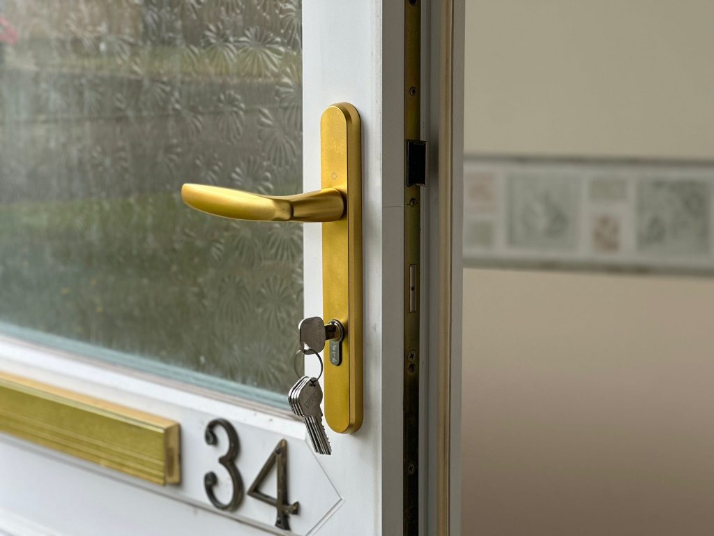 Gold handle and new cylinder on a white front door in Woodthorpe