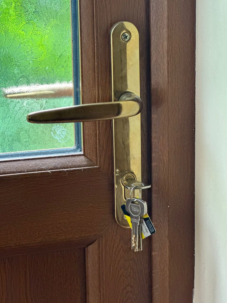 Brass furniture and 3-star cylinder on a woodgrain door in Gedling