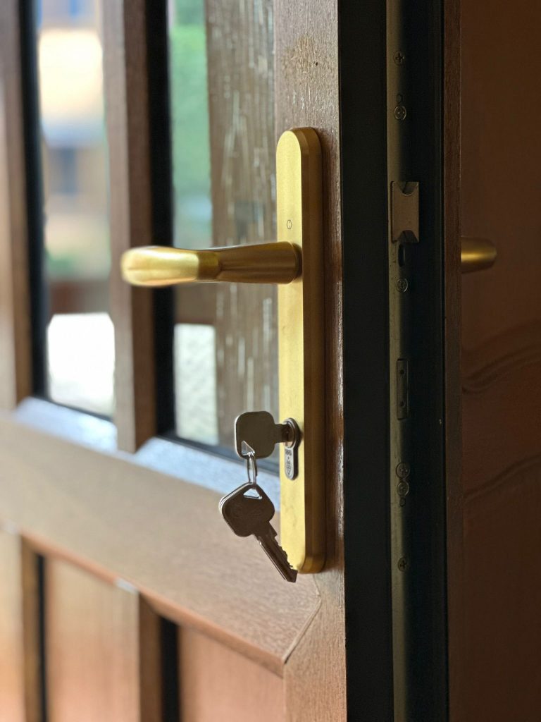Gold lever handle and new cylinder on a glazed timber door in Belper